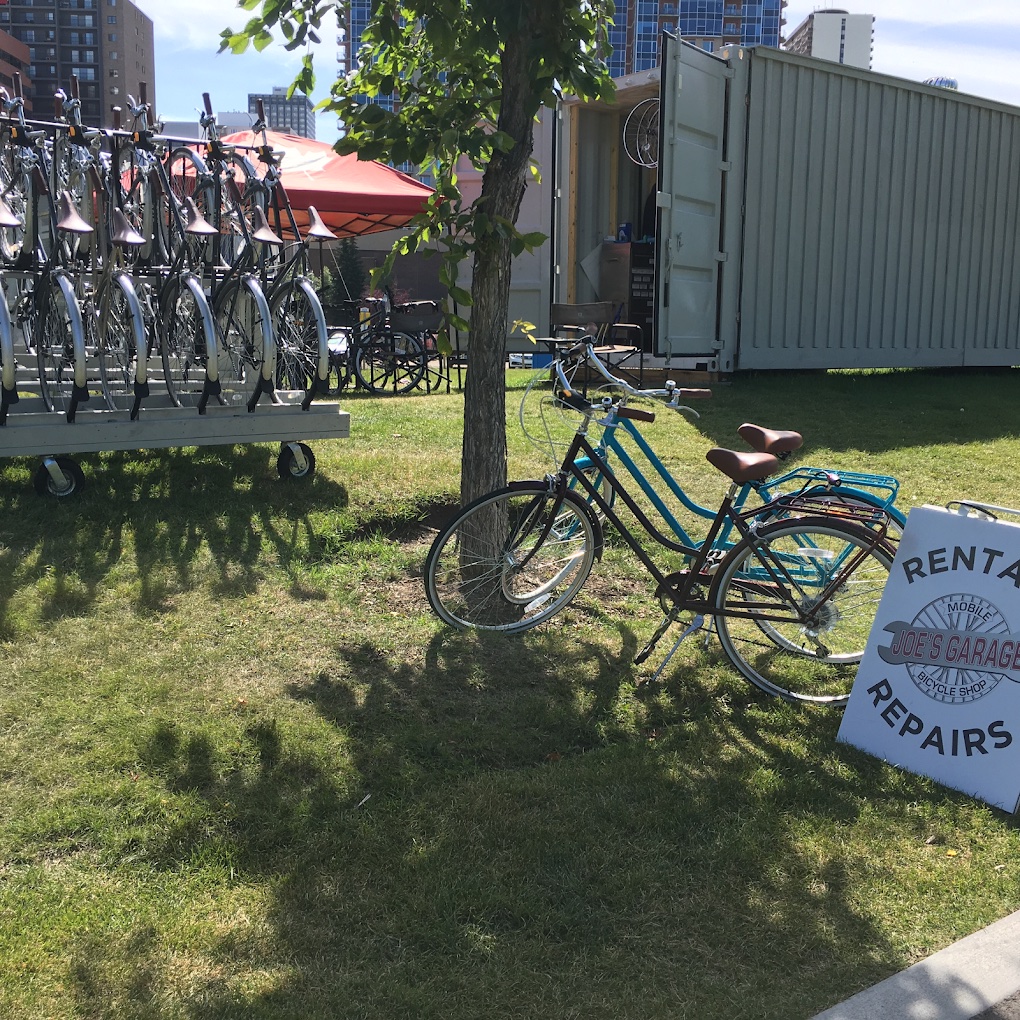 Joe's Garage — rental fleet and shipping container shop with Calgary skyline