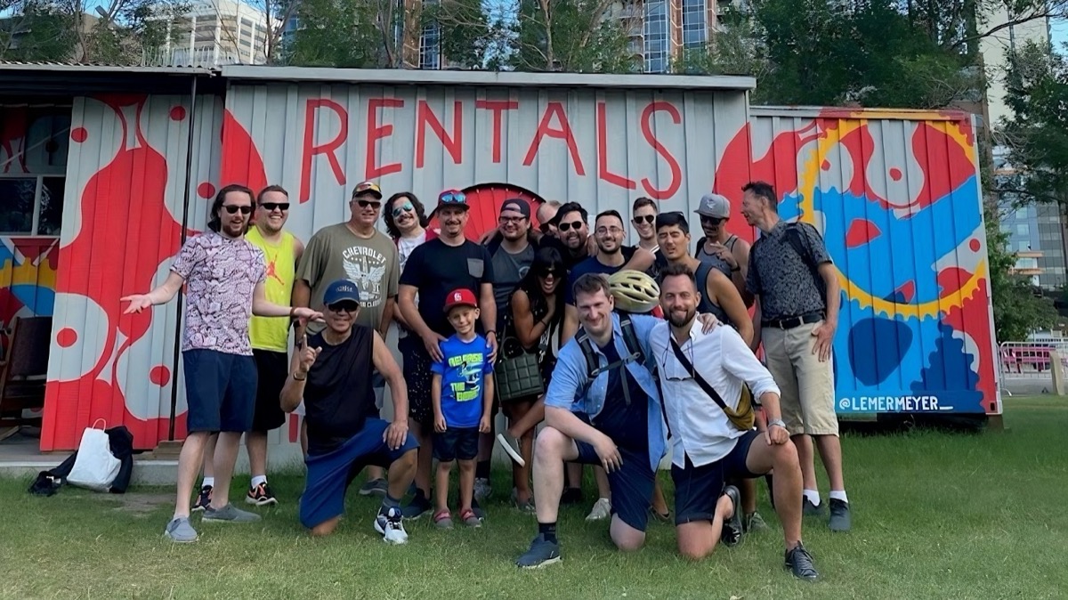 Community group photo in front of the painted shipping container